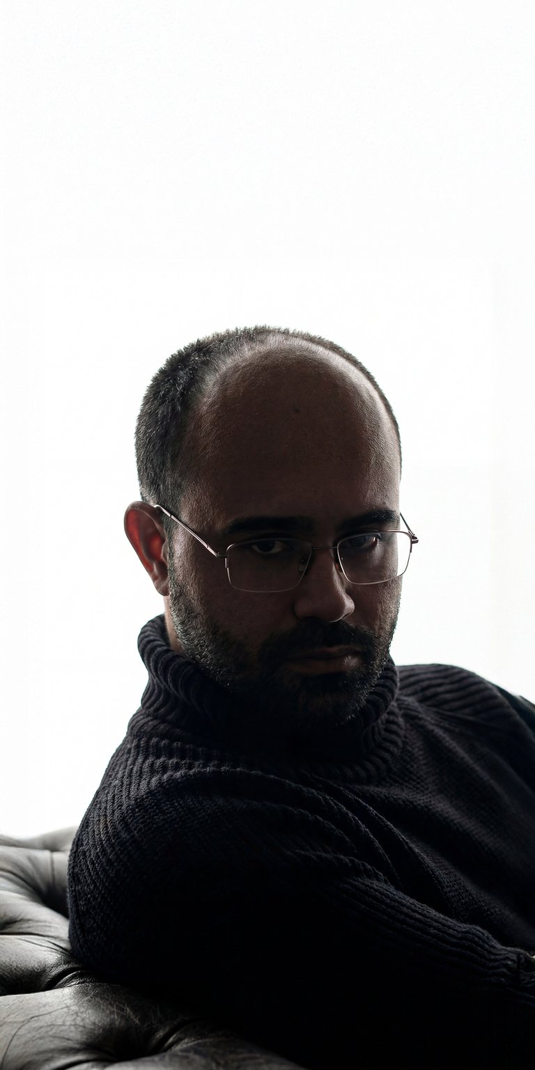 A minimalist aesthetic wallpaper featuring the viral Danny Slicer in a relaxed silhouette pose with hands in his pockets. This high-contrast iPhone wallpaper uses bold lighting against a white background to create a clean, modern look for your lock screen.