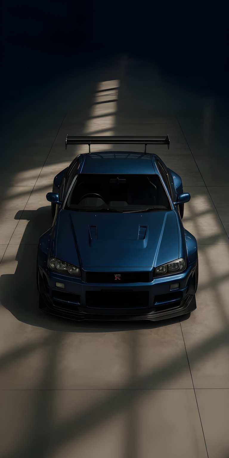 This OLED wallpapers entry showcases a blue Nissan Skyline R34 in a moody, low-light garage setting. Perfect for your iPhone, this high-contrast wallpaper features dramatic shadows and sharp metallic highlights.