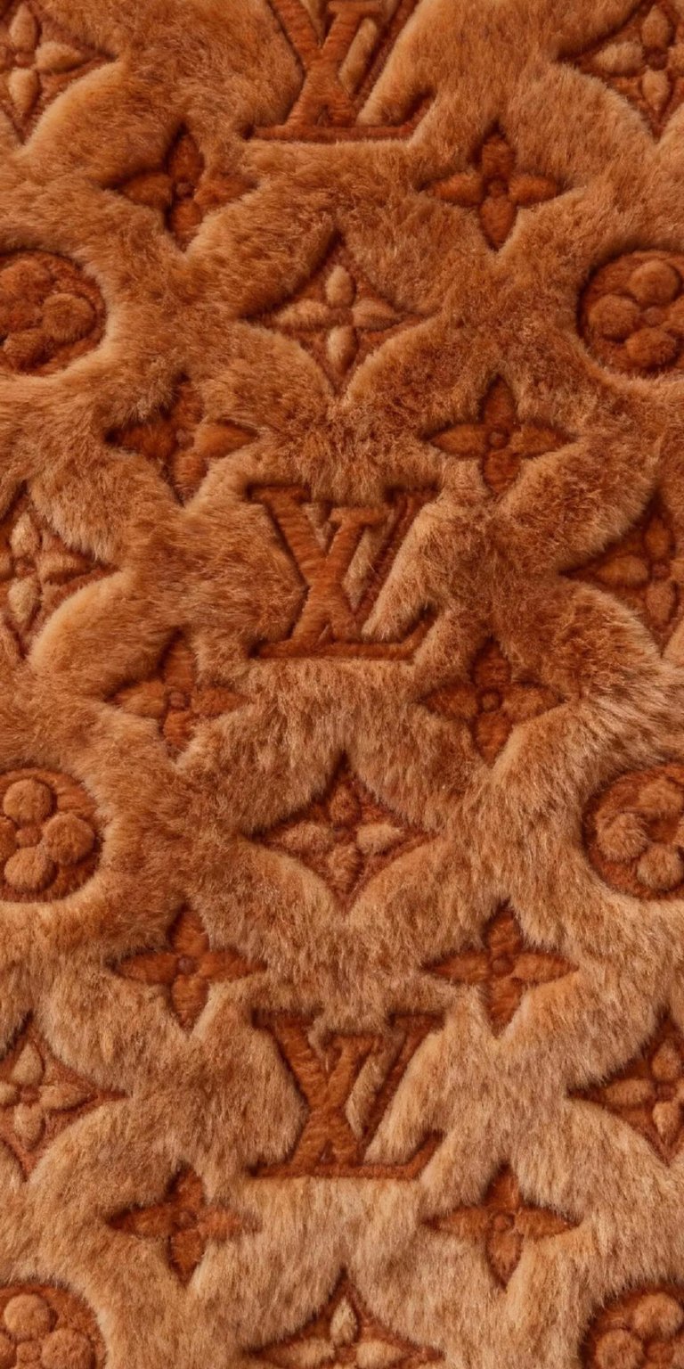 Adorn your iPhone with this luxurious Louis Vuitton 4K wallpaper, showcasing a plush, furry texture in a warm brown hue. The iconic LV logo and floral quatrefoils are intricately embossed, creating a decadent visual experience for your phone.