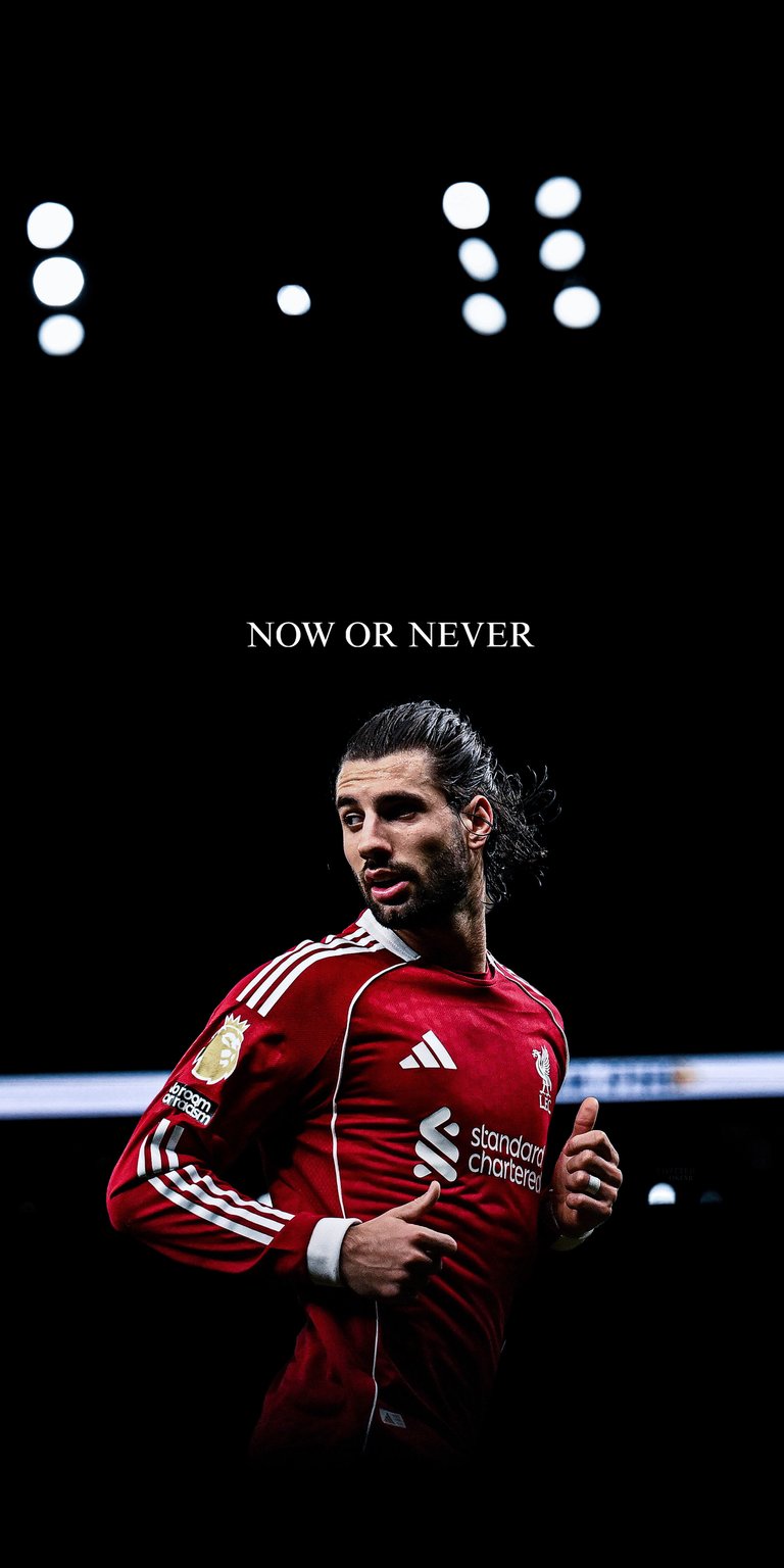 A striking 4K vertical wallpaper featuring Liverpool’s midfield star Dominik Szoboszlai. The image highlights the player in the classic Liverpool home kit against a deep black background, emphasizing the "NOW OR NEVER" motivational quote. It’s a sharp, high-contrast edit designed for Reds supporters who value a minimalist and powerful aesthetic.