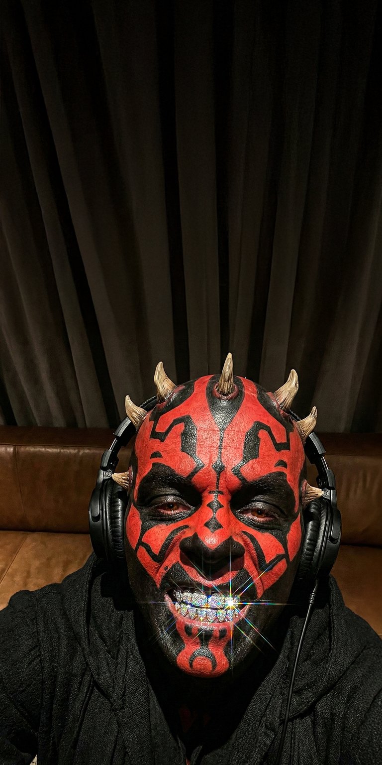 This Darth Maul 4K wallpaper features the iconic Sith Lord with diamond grills and headphones against a deep black background. Perfect for your iPhone, this entry in our OLED wallpapers collection highlights striking red and black contrast with brilliant, sparkling jewelry details.