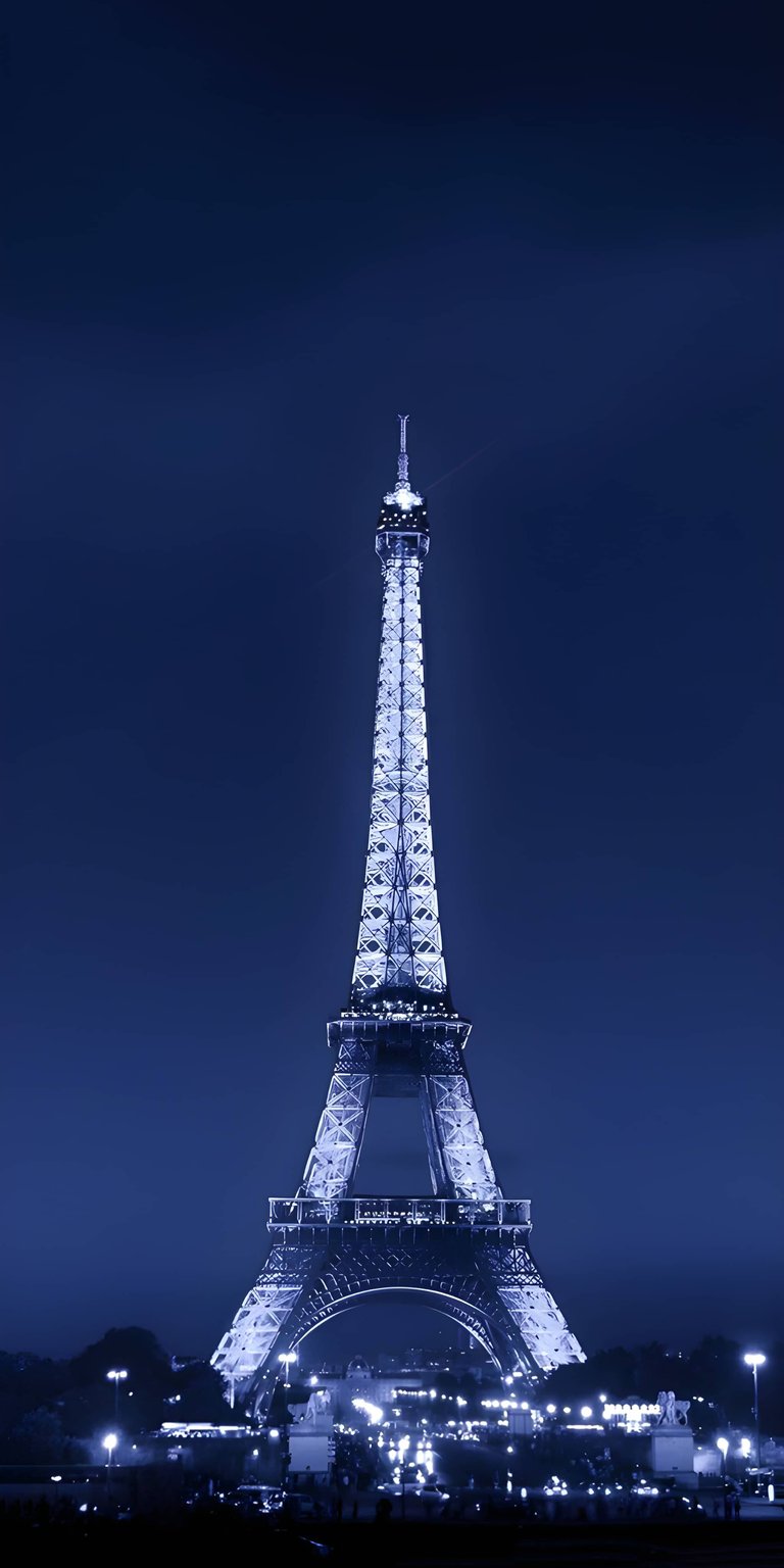 Download this stunning Eiffel Tower night 4K wallpaper featuring the iconic French landmark illuminated against a deep blue evening sky. This premium mobile wallpaper is perfectly optimized for your iPhone to showcase intricate architectural details and shimmering lights in high resolution.