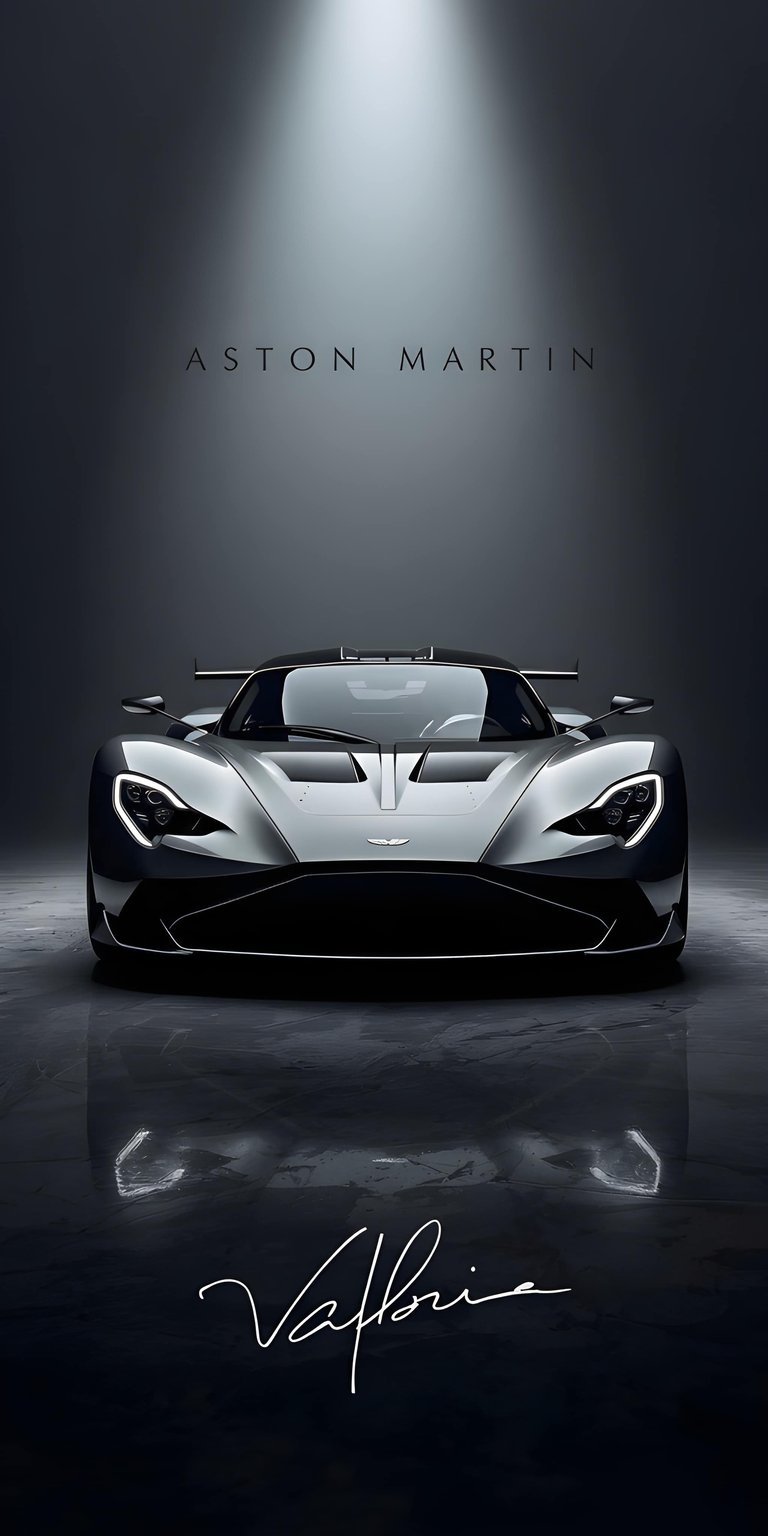 This Aston Martin Valhalla 4K wallpaper features a sleek silver supercar under a dramatic spotlight, perfect for any iPhone user. The high-contrast OLED / AMOLED wallpaper style emphasizes the sharp lines and dark reflections of the vehicle's design.