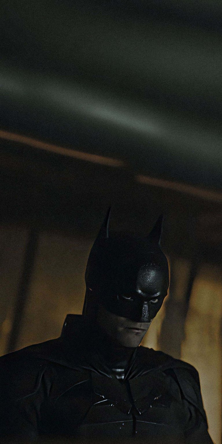 Download this striking Batman wallpaper in 4K for your iPhone. The wallpaper features Batman in his dark suit and cowl, with a brooding expression.