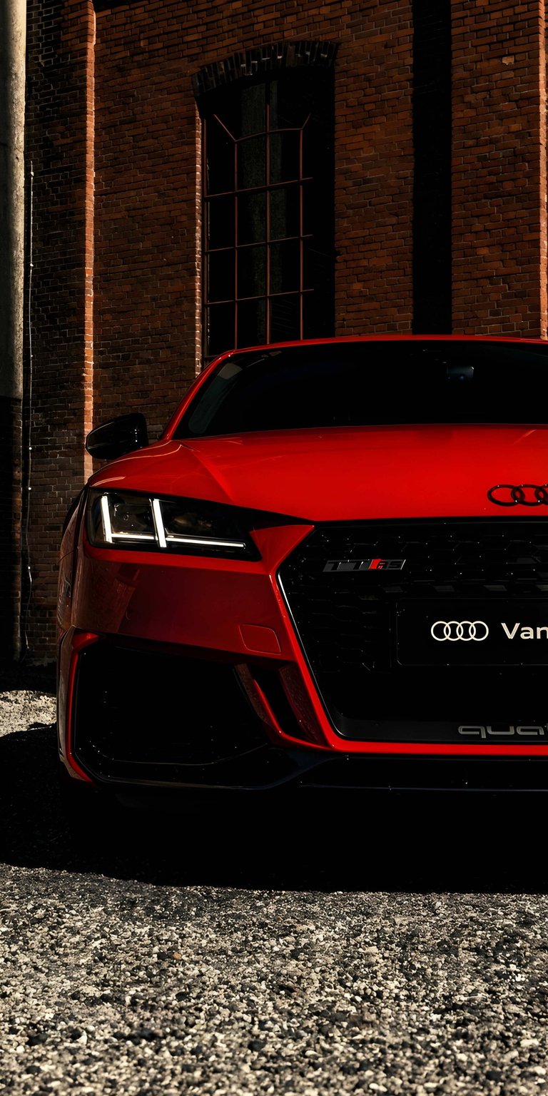 A vibrant red Audi TT showcased with a 3D spatial depth effect. This automotive aesthetic wallpaper highlights the iconic curves and sporty front profile for your iPhone.