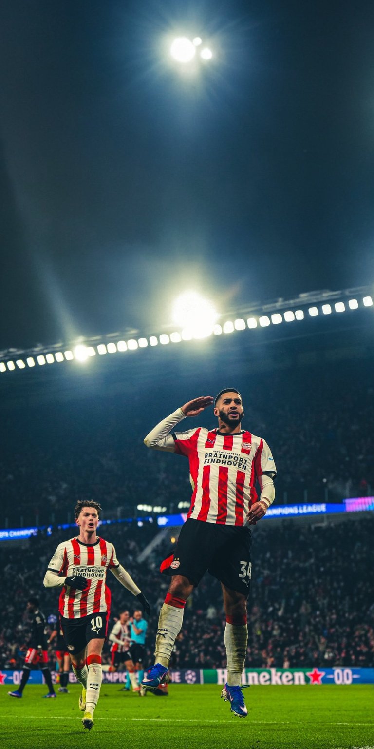 Enhance your mobile screen with this high-resolution Ismael Saibari wallpaper featuring the PSV star under cinematic stadium floodlights. This 4K wallpaper captures the authentic kit textures and vibrant green pitch for a professional aesthetic on any iPhone.