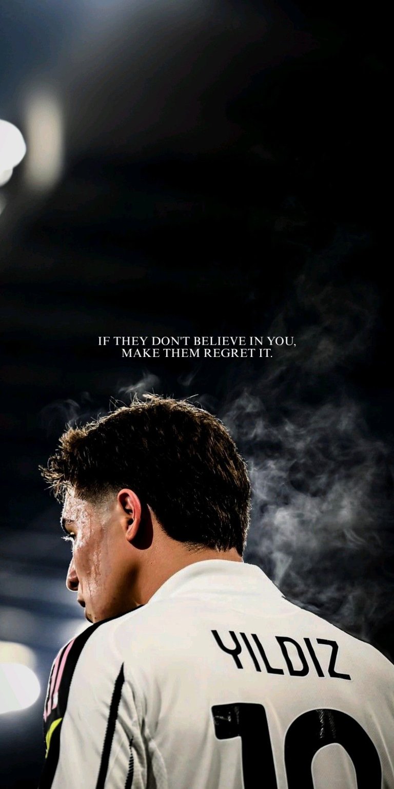 A sleek and moody profile shot of Juventus star Kenan Yıldız. Dressed in the iconic black and white Bianconeri kit, the wallpaper features a dark, smokey background with motivational text. Perfect for Juventus fans and supporters of the rising Turkish talent.