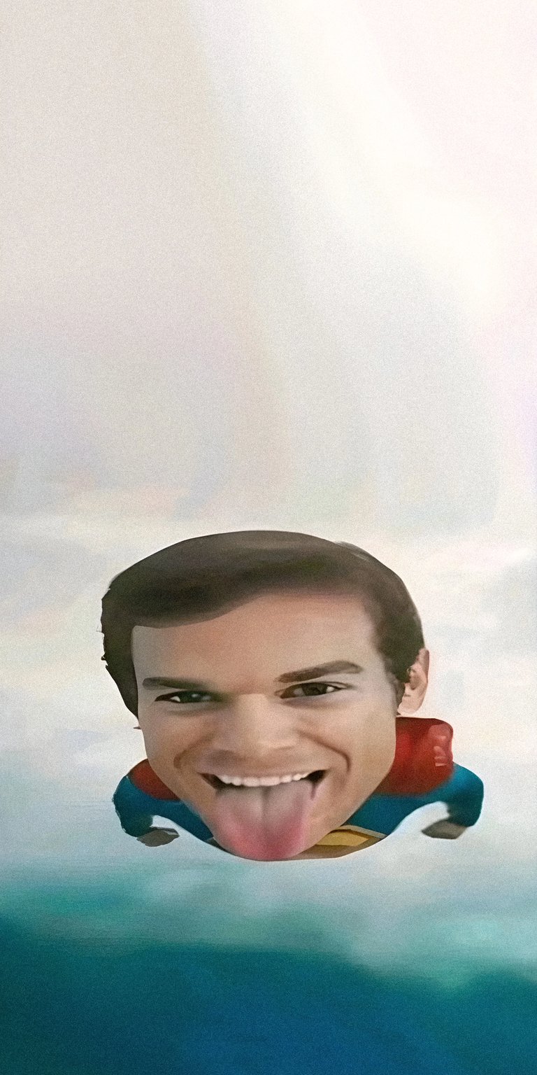 Download this Michael C. Hall 4K wallpaper for your iPhone today! This comical wallpaper depicts the actor with his tongue out while wearing a Superman suit, set against a blue and white sky.