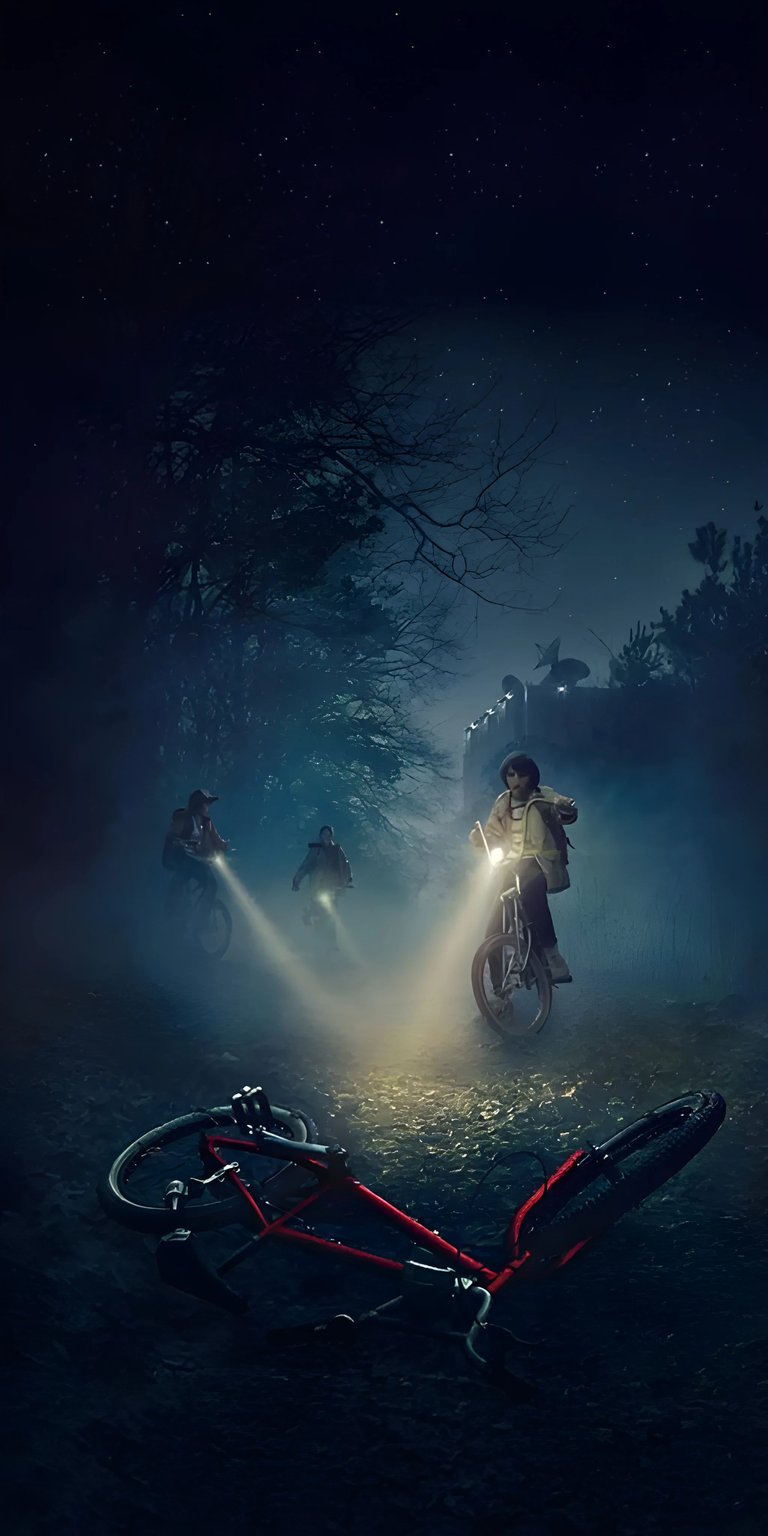 Download this Stranger Things wallpaper in 4K for your iPhone, featuring a group of kids on bikes in a foggy forest. A fallen red bicycle rests in the foreground, while lights from the bicycles illuminate the dark path ahead, adding a mysterious touch to this striking wallpaper.