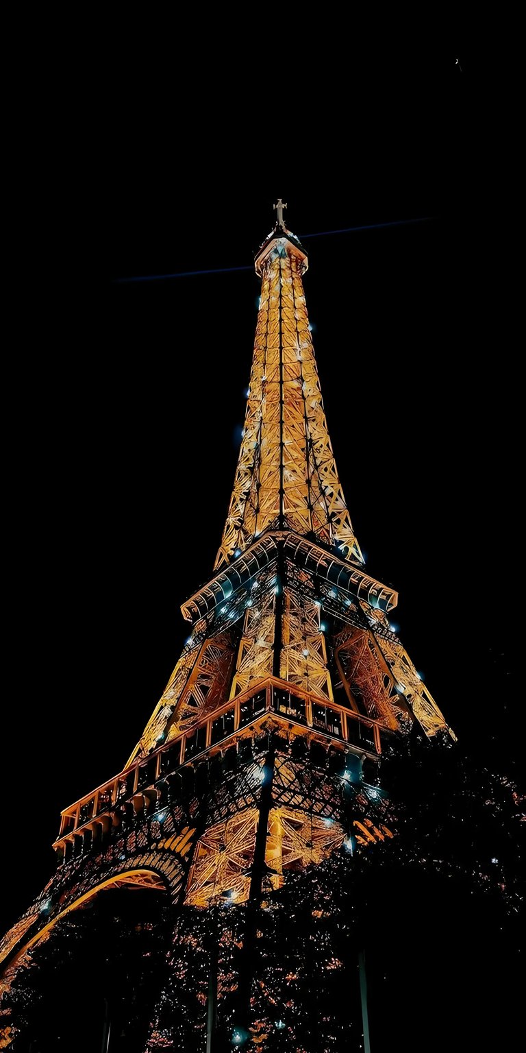 Download this stunning Eiffel Tower 4K wallpaper for your iPhone! Featuring the illuminated spire against a black sky, with rows of twinkling lights, this wallpaper creates a dramatic and captivating aesthetic.