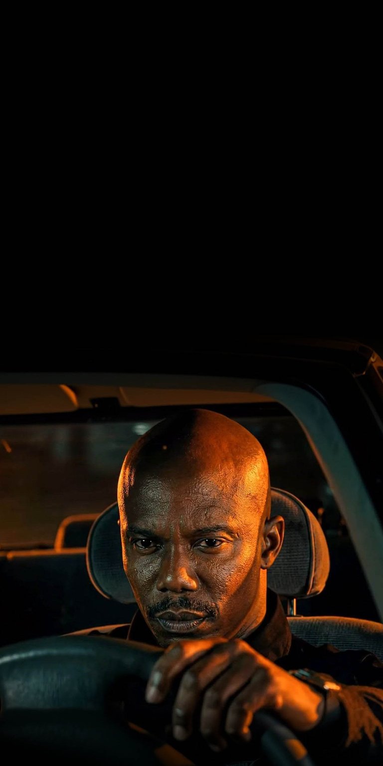 This James Doakes 4K wallpaper is perfect for fans of Dexter looking for high-contrast OLED wallpapers. The cinematic image features Doakes inside a car with intense orange lighting against a deep black background for a moody iPhone lock screen.