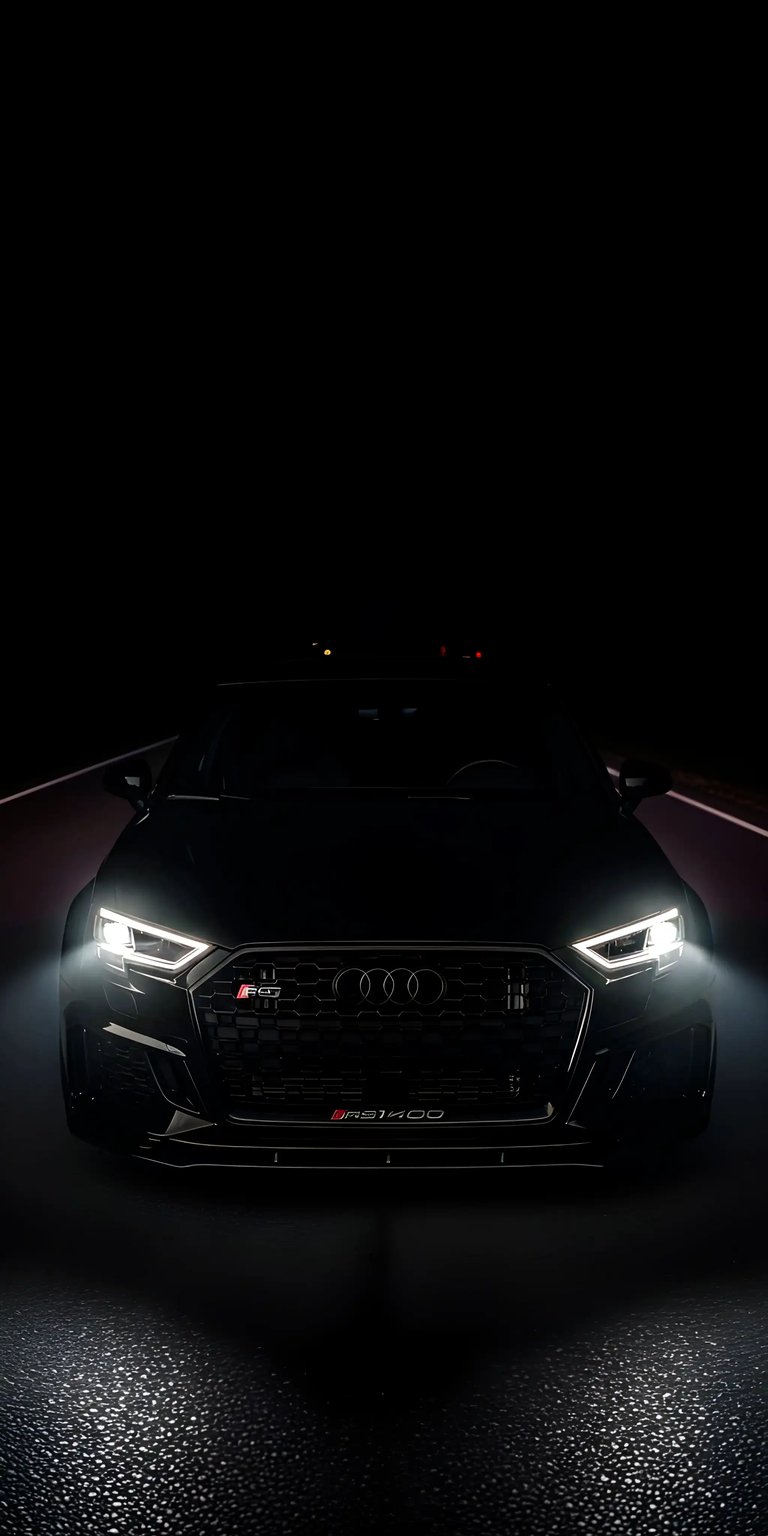 Get this Audi RS3 wallpaper for your iPhone in stunning 4K resolution. This wallpaper features a sleek black car with bright headlights illuminating the road, and a distinctive RS3 badge.