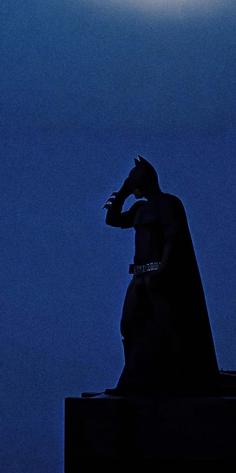 Download this Batman 4K wallpaper for your iPhone, showcasing a silhouette against a dark blue sky. This wallpaper features Batman wearing his iconic cowl, his cape flowing, and his utility belt.