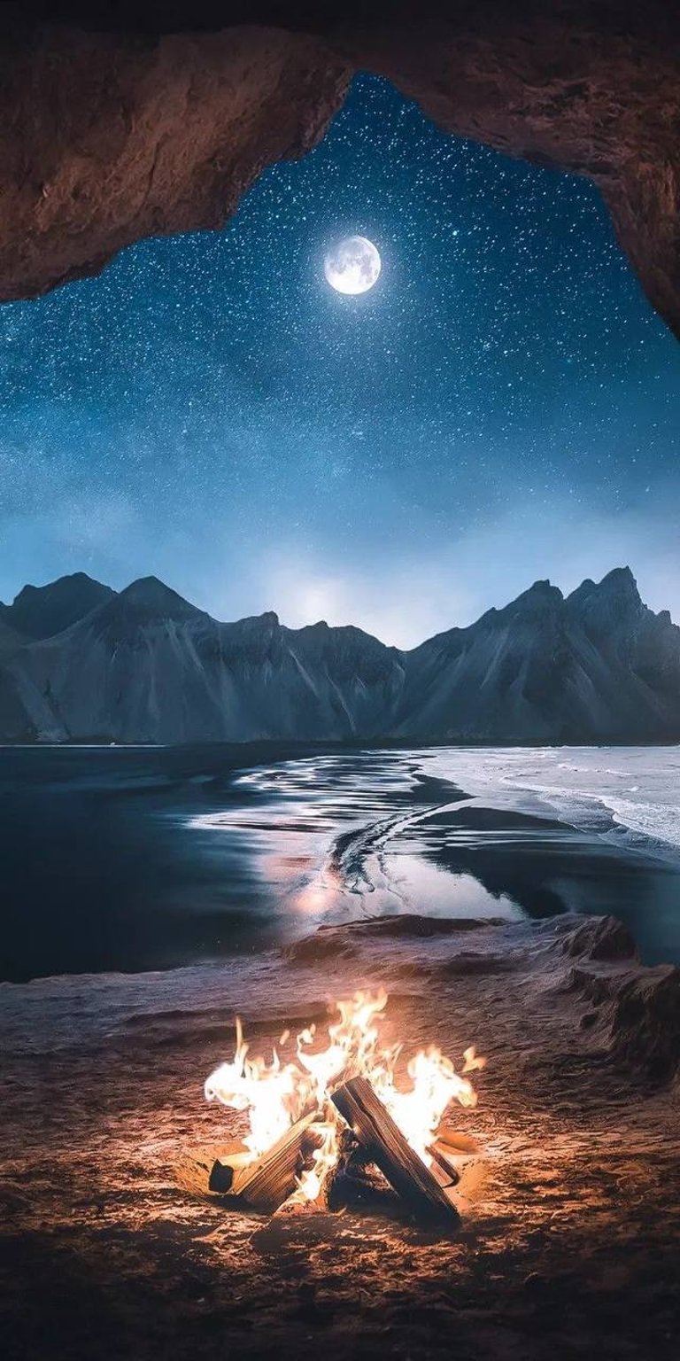 Camp fire on the beach with mountain view night sky wallpapers