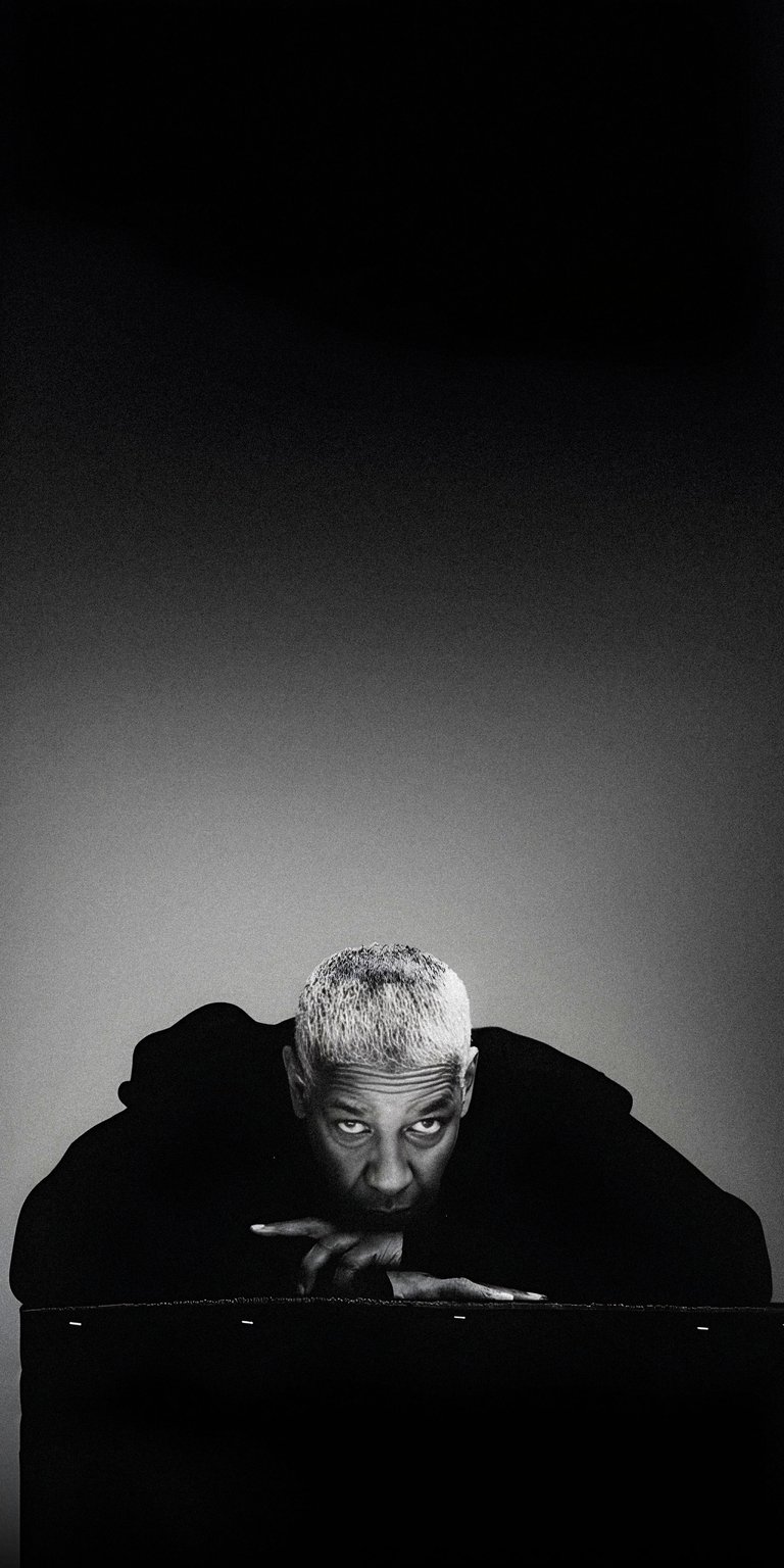 A moody black and white aesthetic wallpaper of Denzel Washington leaning forward. This high-contrast wallpaper provides a sophisticated and cinematic look for your iPhone.