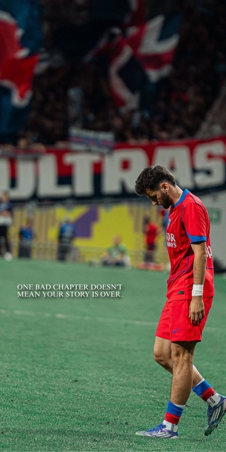 A raw and emotional 4K wallpaper featuring Napoli and Georgia star Khvicha Kvaratskhelia walking off the pitch in his kit, set against a blurred, intense crowd background. The dark, distressed filter and gritty texture highlight the weight of the moment, creating a powerful aesthetic.