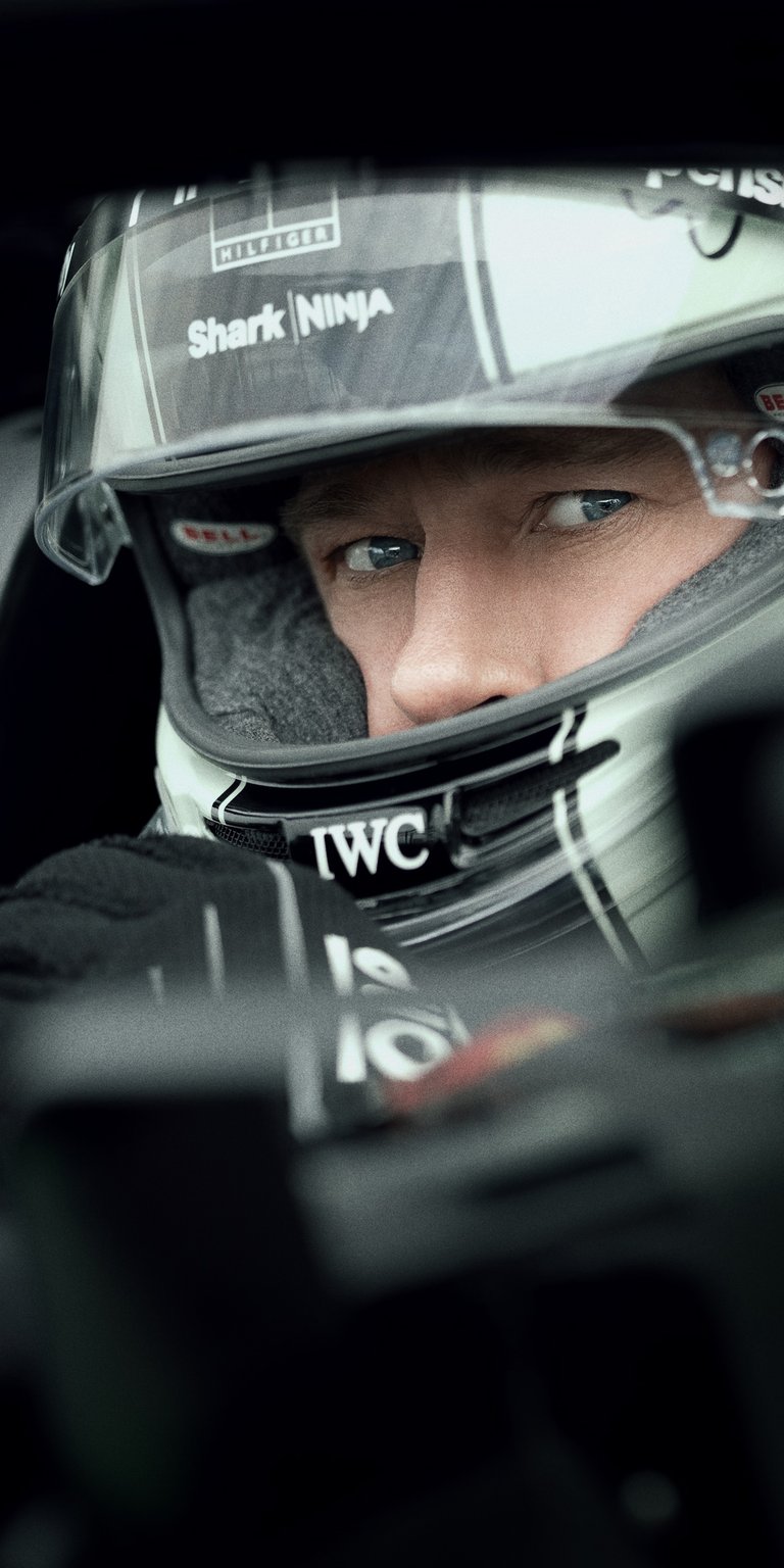 Brad Pitt F1 4K Wallpaper featuring Brad Pitt in a racing suit with dramatic lighting and cinematic depth. This aesthetic wallpaper for iPhone captures motorsport intensity and sharp portrait detail, making the wallpaper perfect for lock screen and home screen setups.