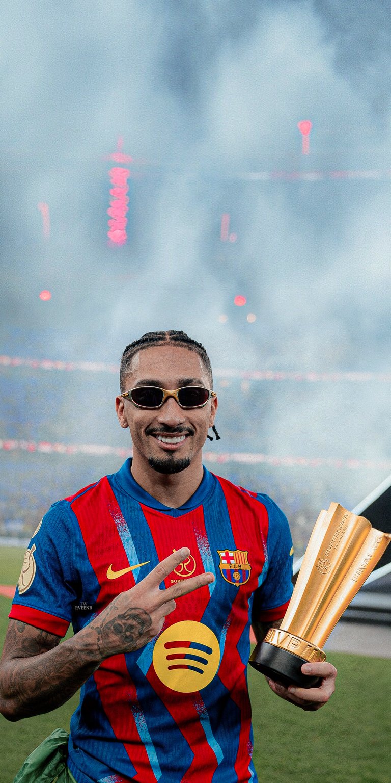 Showcase your pride with this 8K Raphinha wallpaper featuring the star winger wearing sunglasses and holding a golden trophy. This stylish iPhone wallpaper captures the smoky atmosphere and vibrant stadium lights of a championship night.