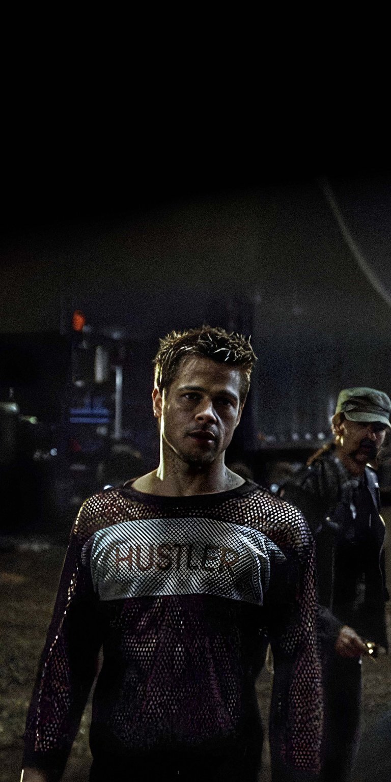 Download this Tyler Durden 4K wallpaper for your iPhone. The wallpaper shows Tyler with spiky hair, wearing a mesh 'Hustler' shirt.