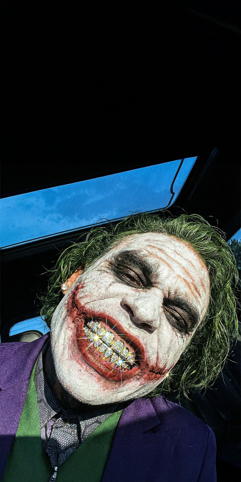 This high-contrast 4K OLED wallpaper features the Joker showing off sparkling diamond grillz. Perfect for your iPhone, the deep black backgrounds make the vibrant green hair and shimmering jewelry glints pop with intense detail.