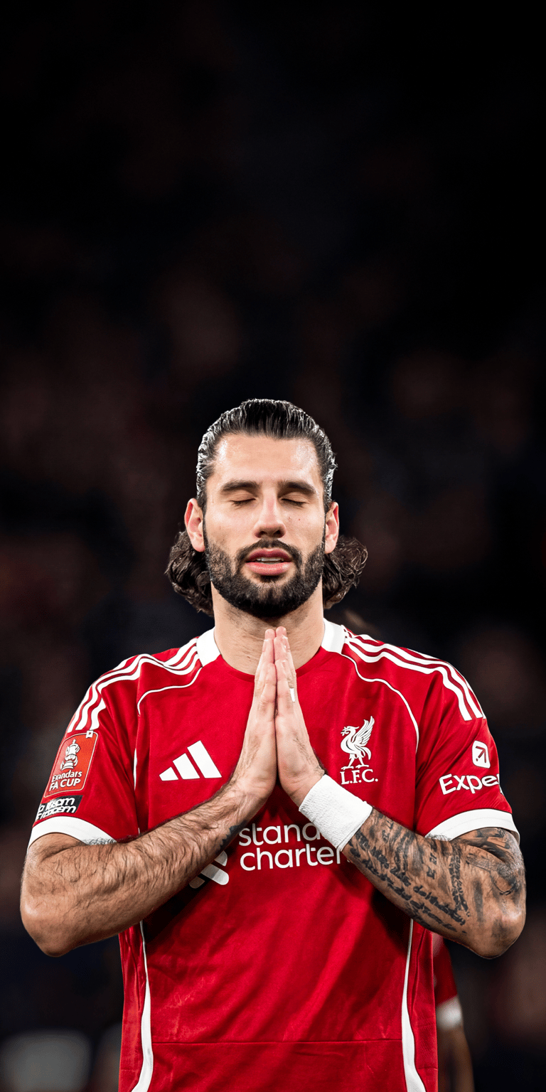 This atmospheric 4K wallpaper features Dominik Szoboszlai in the classic Liverpool red kit in a moment of prayerful focus. A stunning choice for any iPhone, this wallpaper emphasizes the detailed Adidas stripes and the Standard Chartered crest against a dark background.