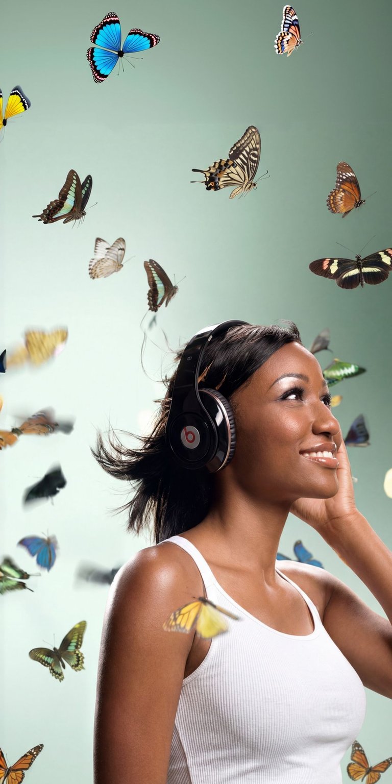 This vibrant 4K wallpaper features a beautiful woman with headphones, surrounded by a swarm of colorful butterflies. This stunning iPhone wallpaper showcases the intricate patterns on the butterflies' wings and the soft, ethereal light.
