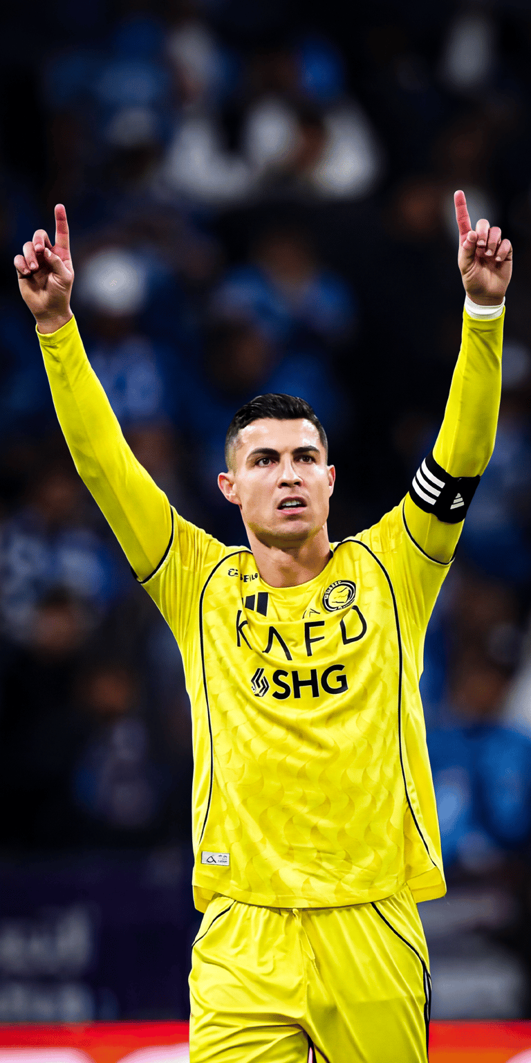 Experience the power of CR7 with this 4K wallpaper showing Cristiano Ronaldo in the bright yellow Al Nassr kit with his fingers pointed to the sky. This iPhone wallpaper captures the "KAFD" sponsor detail and the intense stadium lighting behind the legendary striker.