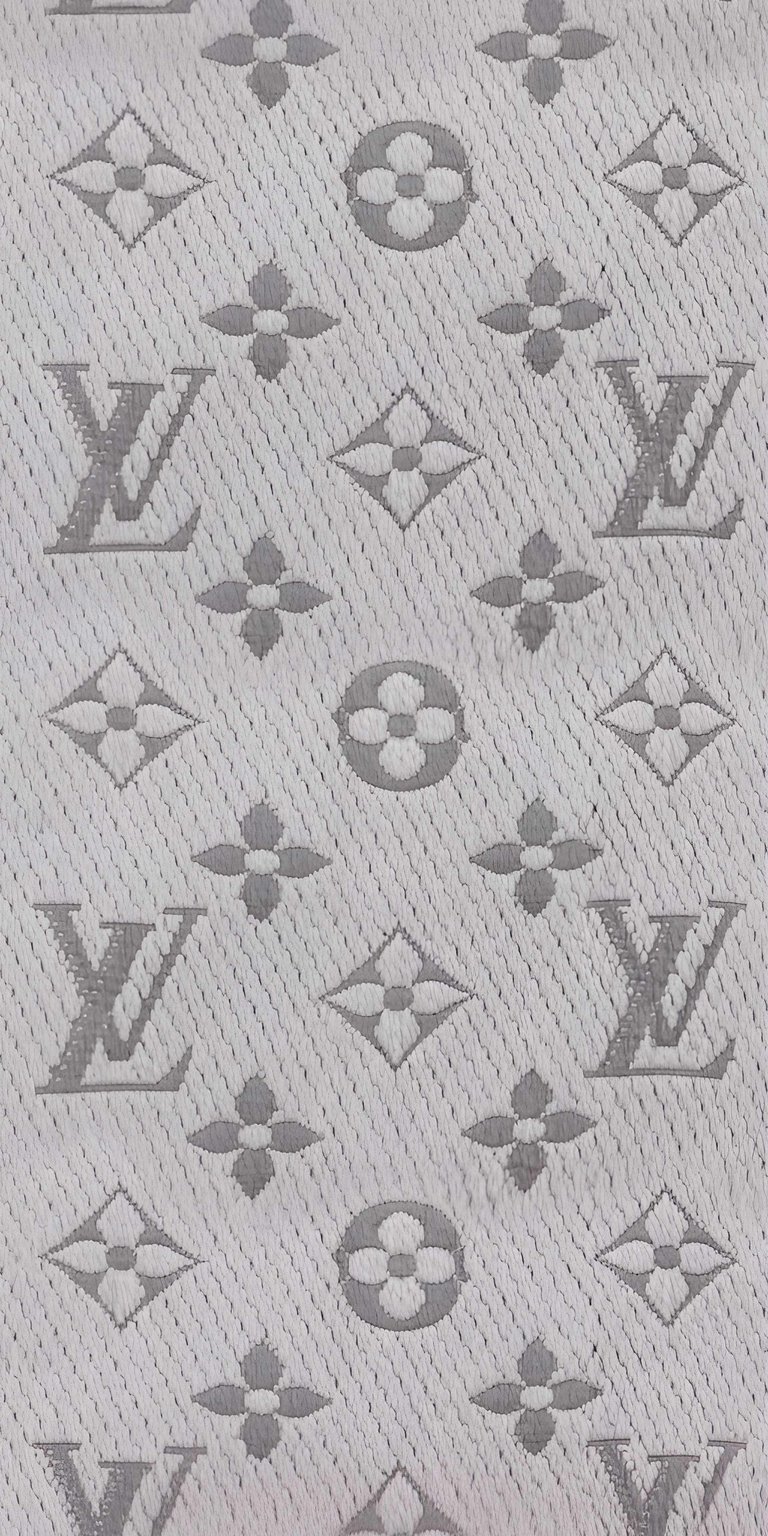 Elevate your iPhone with this stylish Louis Vuitton 4K wallpaper. This wallpaper features the classic LV logo, floral quatrefoils, and diamond shapes, all elegantly displayed with a subtle texture.
