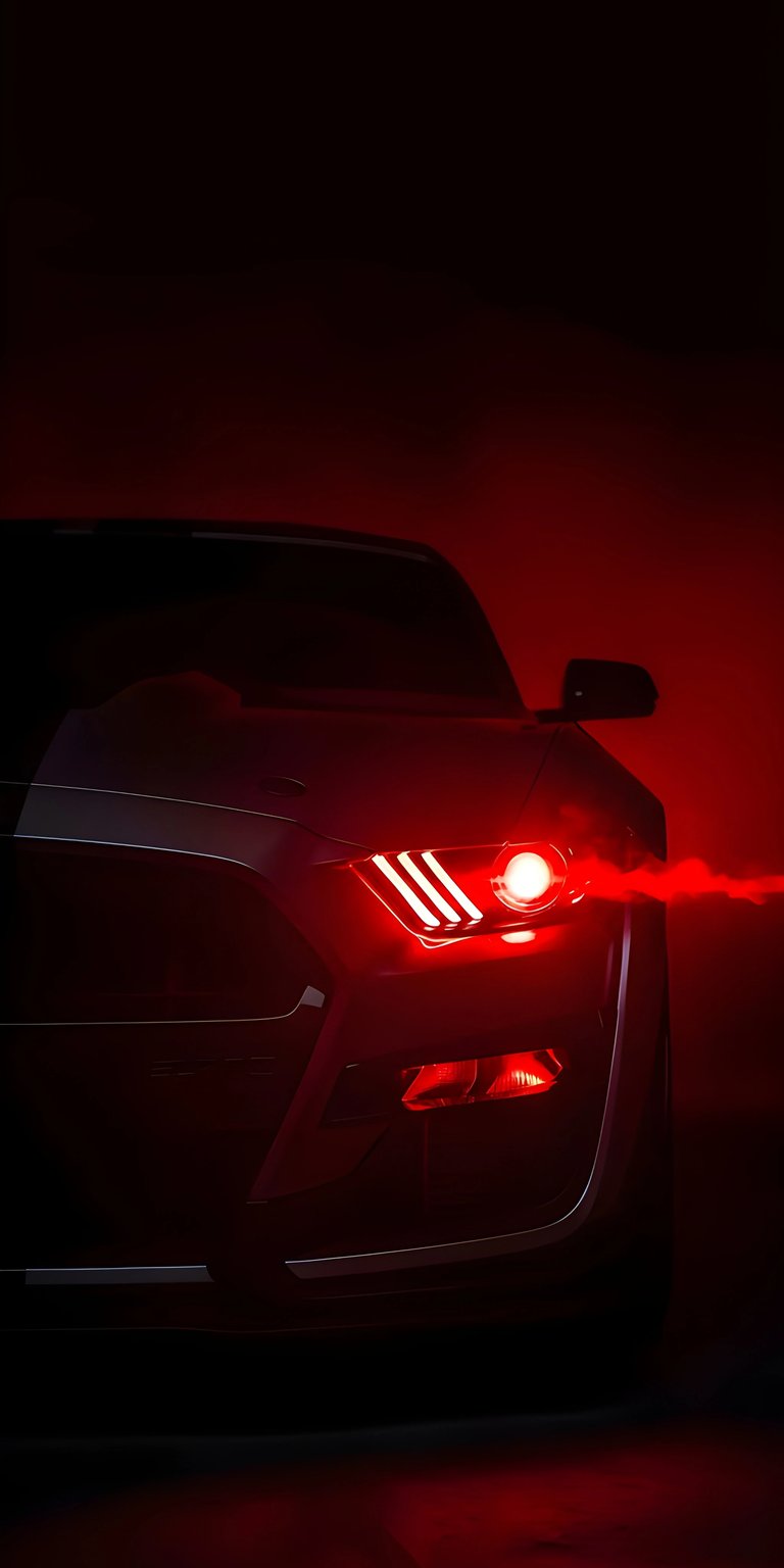 Bring a fierce edge to your iPhone with this Ford Mustang 4K OLED wallpaper featuring the iconic triple-slat red glowing headlight. This high-contrast wallpaper showcases dramatic crimson lighting and smoke effects against a deep, pitch-black background.