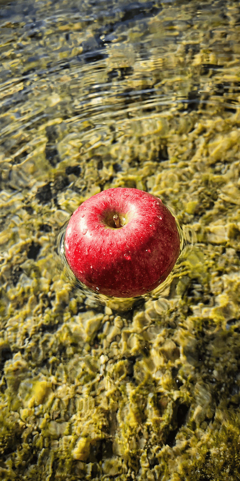 This 3D wallpaper captures a red apple submerged in dark, rippling water. The moody lighting and reflections create a sophisticated aesthetic wallpaper for iPhone.