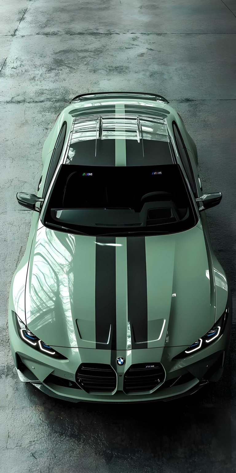 This BMW M4 CSL 4K wallpaper features a striking overhead view of the performance coupe in a unique sage green finish with black racing stripes. Designed as a high-quality iPhone wallpaper, the image highlights the aggressive hood vents and signature LED headlights against a gritty, industrial concrete backdrop.