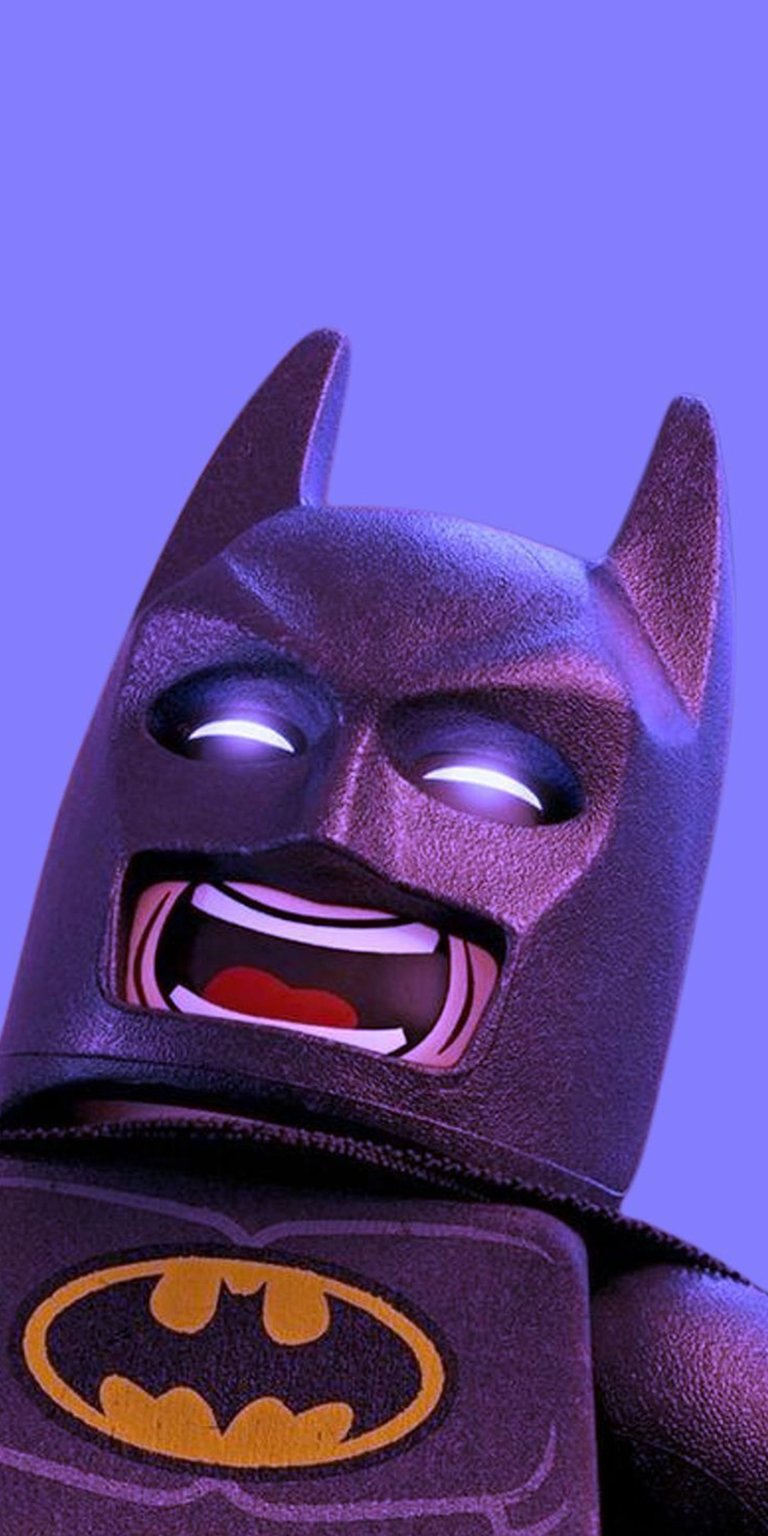 Download this 4K Lego Batman wallpaper for your iPhone! The Lego Batman figure has glowing white eyes, a red mouth and a yellow emblem on his chest.