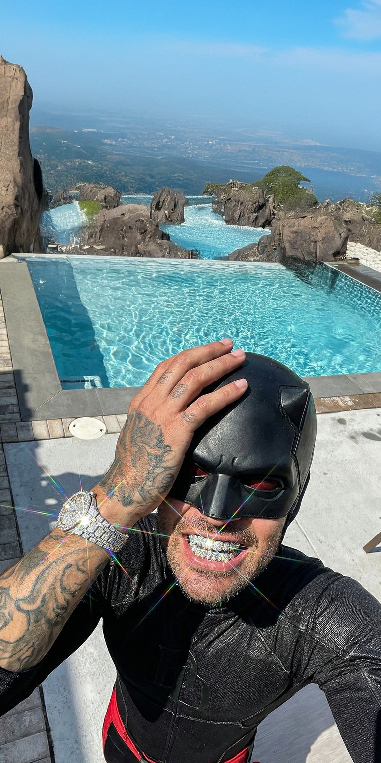 This 4K aesthetic wallpaper features Daredevil posing at a luxury pool while rocking iced-out diamond grillz and a sparkling watch. Perfect for your iPhone, this wallpaper captures a sunny outdoor vibe with vibrant blue water and bright, shimmering lens flares.