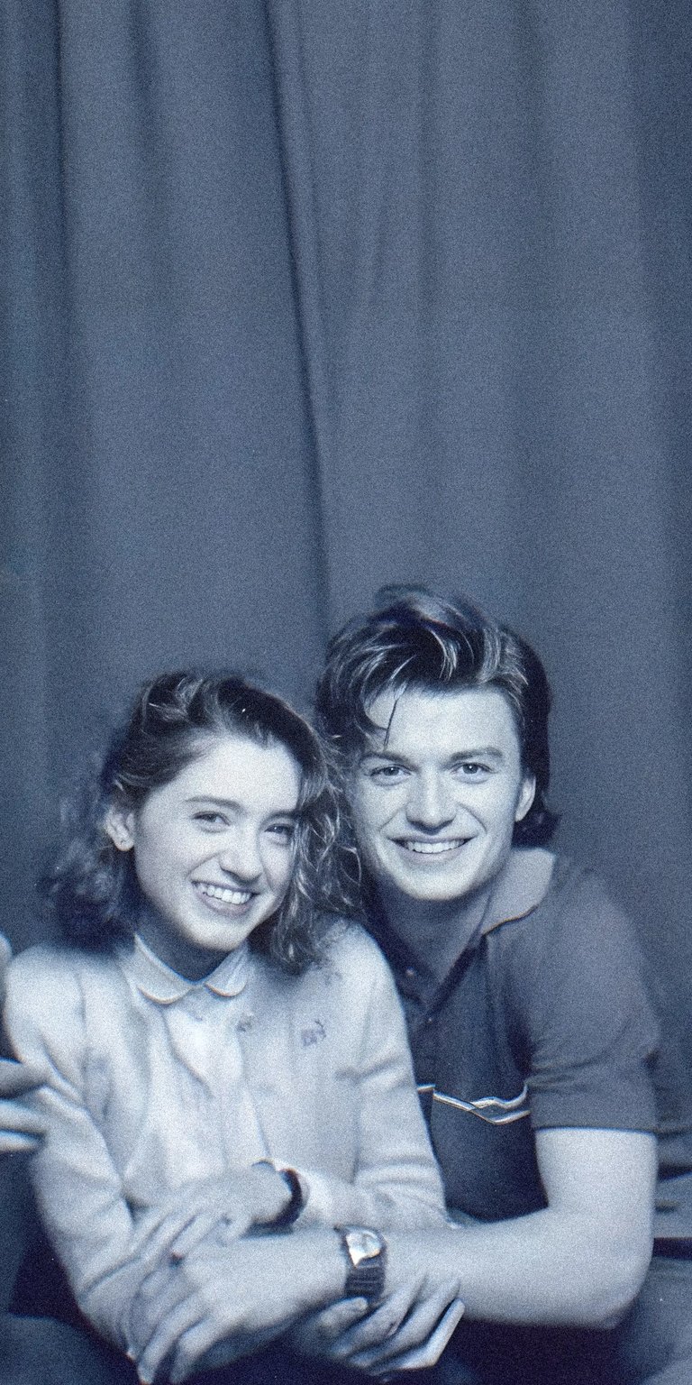 Download this vibrant Steve and Nancy 4K wallpaper for your iPhone, showcasing their smiles, wavy hair, and coordinating polo shirts. It's the perfect wallpaper to celebrate your favorite show!