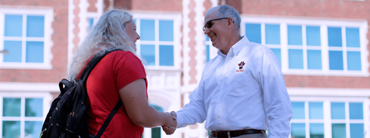 Student and board member shaking hands