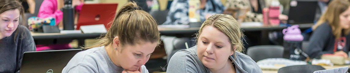 Two students helping each other in class