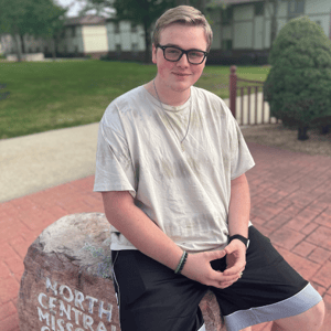 Student sitting on the NCMC rock