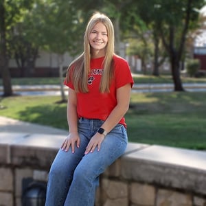 Student sitting by Geyer Hall lawn