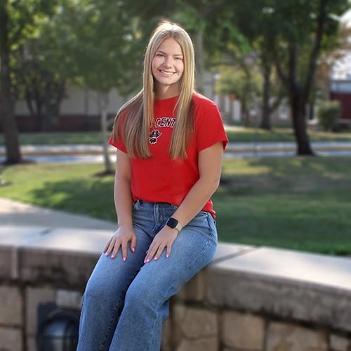Student sitting by Geyer Hall lawn