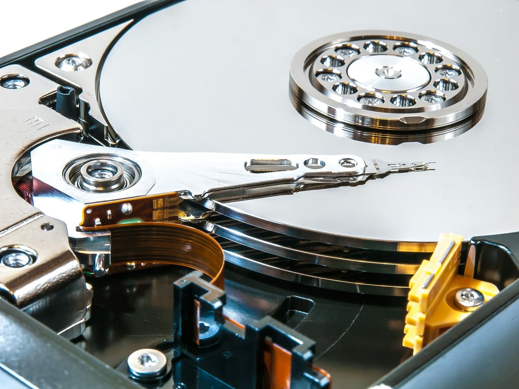 The inside of an open hard drive, showing the platters and the actuator arm.