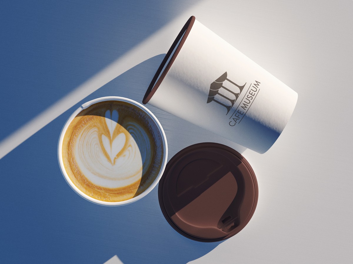 Cafe Museum branded coffee cup, overhead with latte art