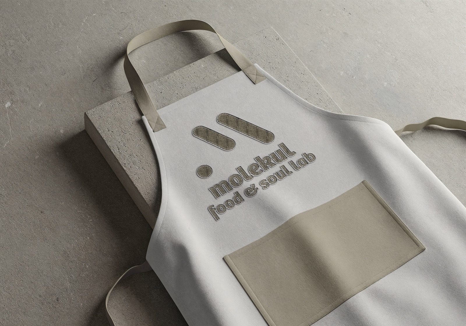 The mark on aprons, tote bags, and tees — worn, not just printed.