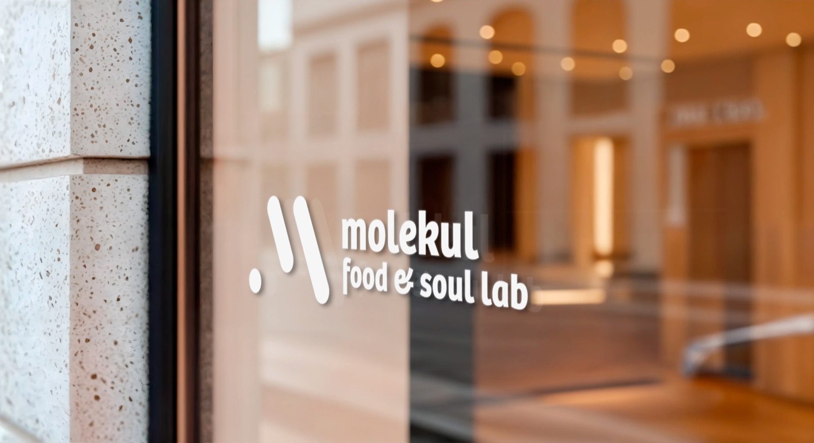 The mark in physical space — window vinyl, neon, or printed signage.