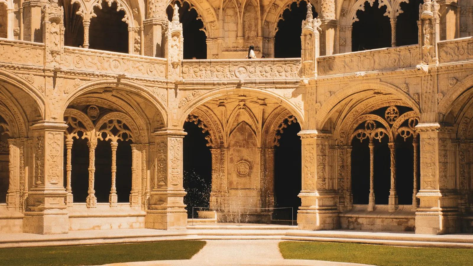 Cloister of the Jerónimos Monastery in Lisbon with richly decorated arches on two levels