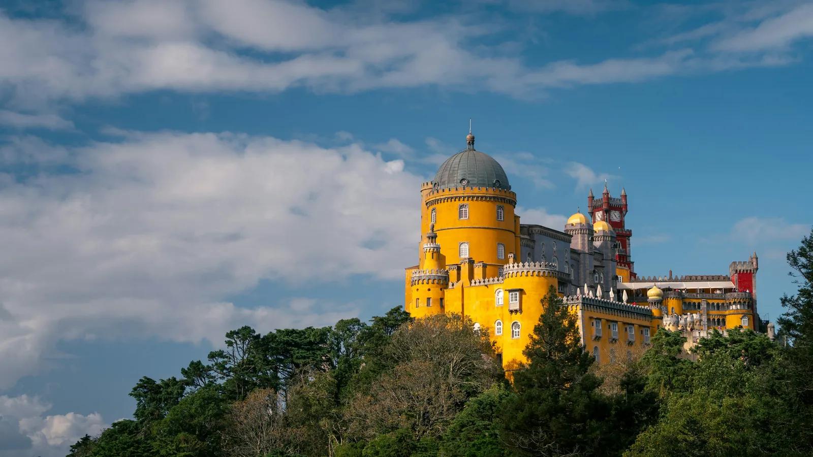 Palácio da Pena in Sintra mit gelbem Turm über dem bewaldeten Hügel