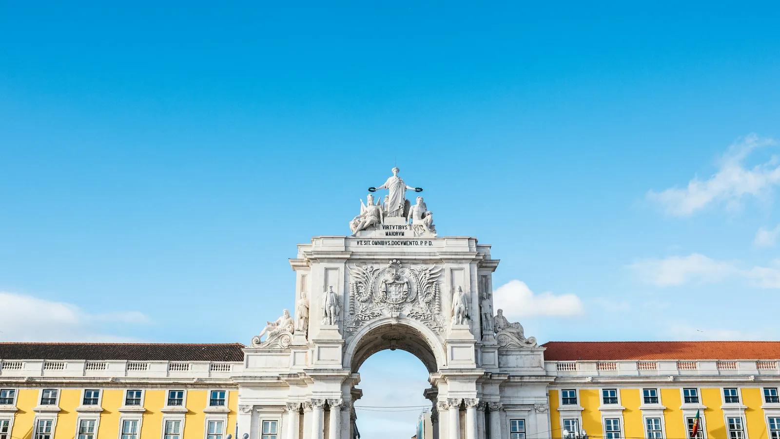 Arco da Rua Augusta an der Praça do Comércio in Lissabon mit gelben Arkadenbauten