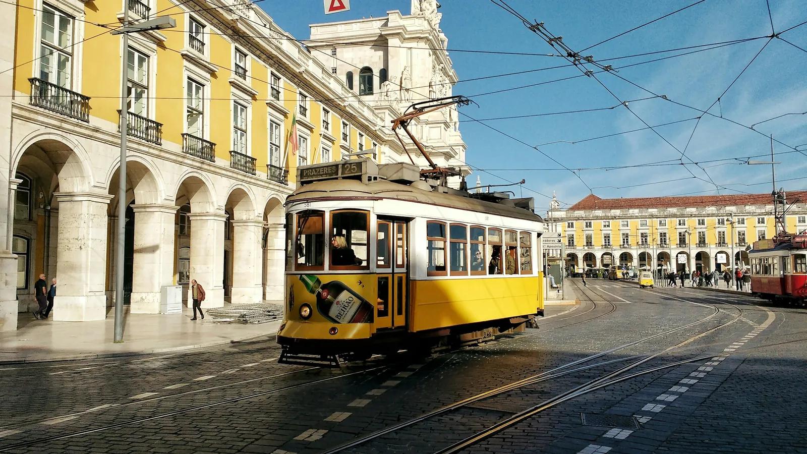 Gelbe Straßenbahn in der Nähe der Praça do Comércio in Lissabon mit Oberleitungen