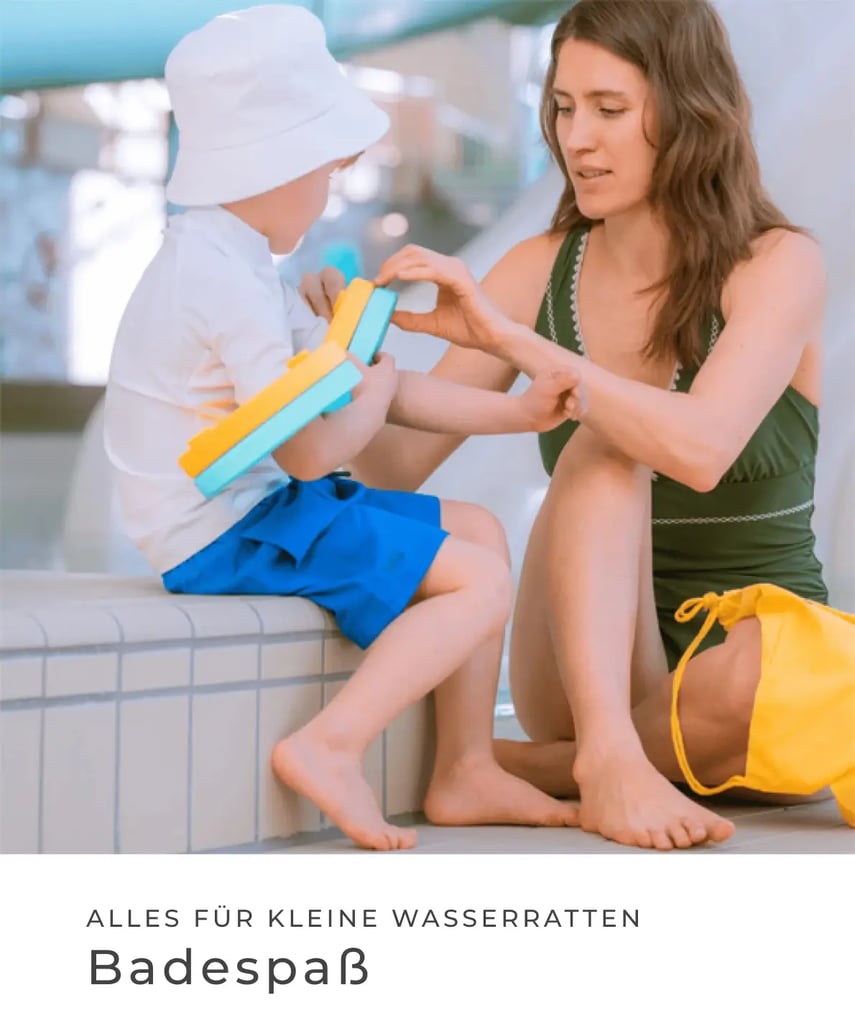 Kind in UV-Schutzkleidung und Sonnenhut sitzt am Beckenrand, während eine Frau Sonnencreme aufträgt. Alles für kleine Wasserratten – Badespaß.