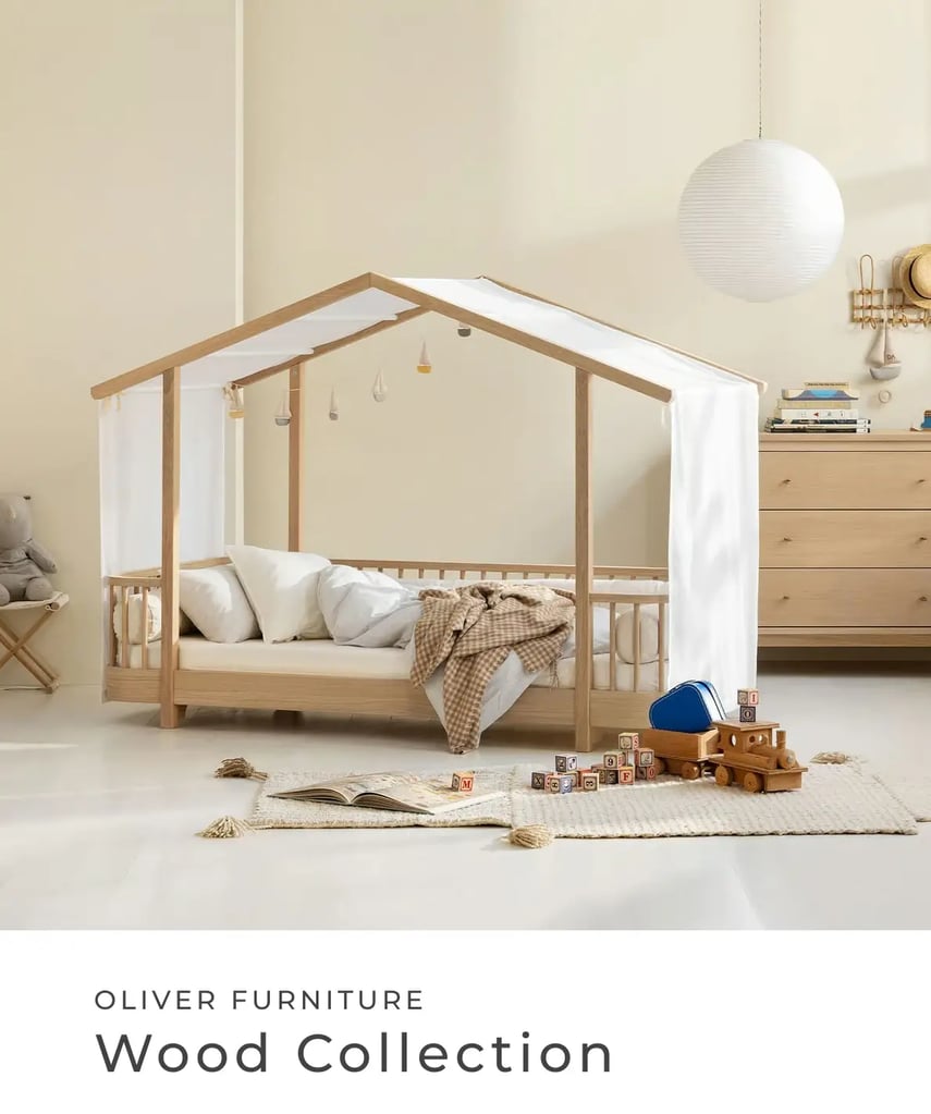 Oliver Furniture: Wood Collection. Helles Kinderzimmer mit Hausbett aus Holz, Spielzeug, Teppich und Kommode.
