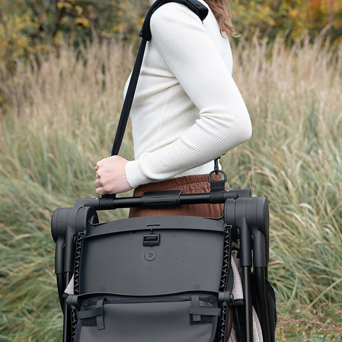 Anglecab A-Series Buggy Frau trägt Buggy über Schulter